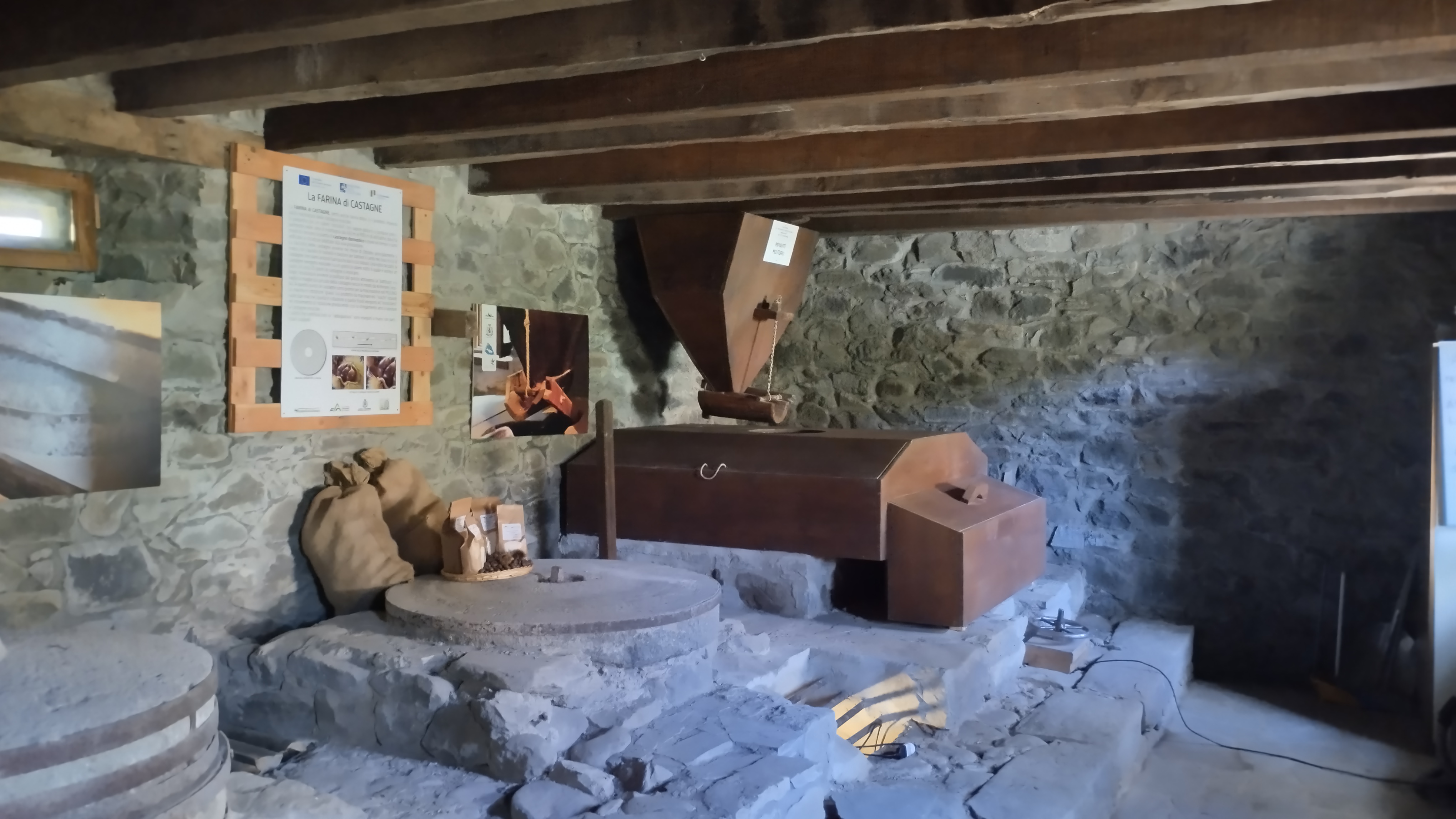  Gli interni della sala del mulino con, in primo piano, la macina antica restaurata e, in fondo, il nuovo impianto molitorio funzionante