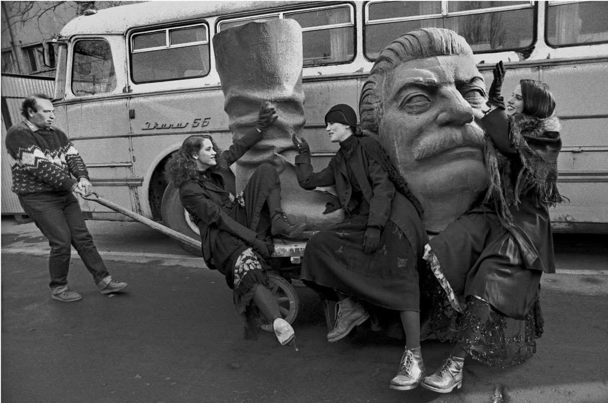 Ferdinando Scianna, Budapest, Ungheria, 1990. Tre allegre ragazze accompagnano Josip Stalin alla pattumiera della storia, 1990, 43x49 cm, ©Ferdinando Scianna
